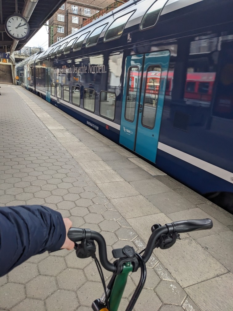 I'm holding a bike at a train station.